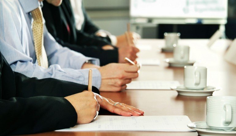Four people next to each other making notes
