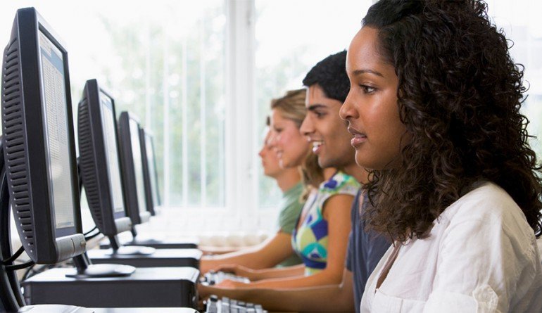 Four women on a computer next to each other