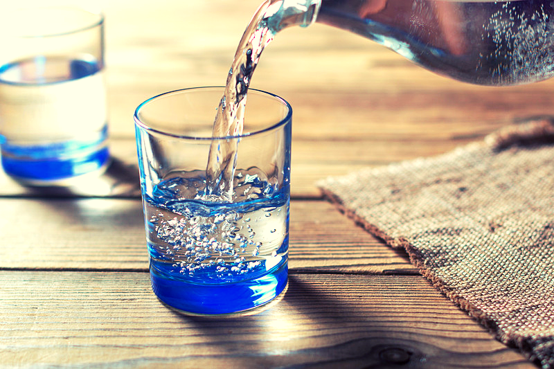 A glass of water being poured