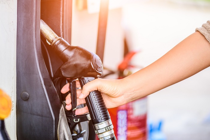 Hand reaching for a gas nozzle