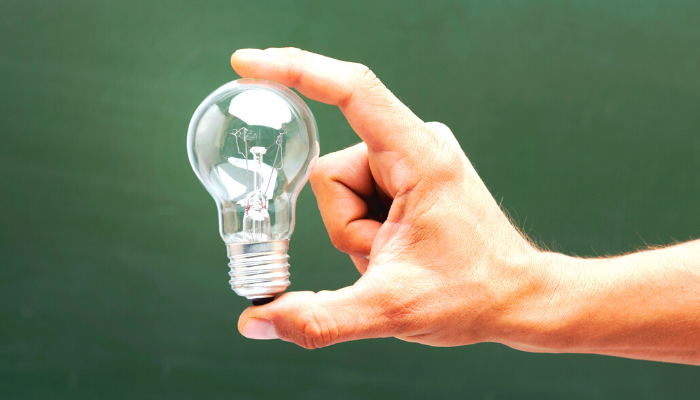 two fingers holding a lightbulb